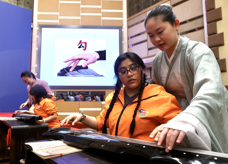 2024年3月20日，美國(guó)華盛頓州中學(xué)生代表團(tuán)北京大學(xué)交流活動(dòng)在北京大學(xué)英杰交流中心舉行。圖為來(lái)自華盛頓州的中學(xué)生體驗(yàn)古琴。