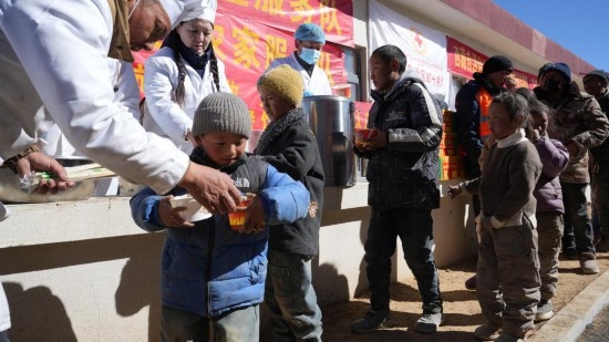 1月14日，廚師們正在給前來(lái)用餐的小朋友們打飯。新華社記者 邱星翔 攝