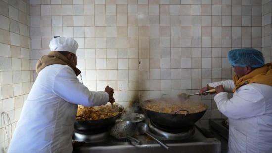 1月14日，服務(wù)隊(duì)的兩名廚師正在為村民們做午飯。新華社記者 邱星翔 攝