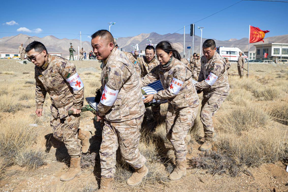 1月9日，日喀則定日縣長(zhǎng)所鄉(xiāng)，西藏軍區(qū)總醫(yī)院醫(yī)療隊(duì)隊(duì)員將受傷村民用擔(dān)架從救護(hù)車(chē)準(zhǔn)備抬上直升機(jī)，轉(zhuǎn)運(yùn)至拉薩的西藏軍區(qū)總醫(yī)院救治。人民日?qǐng)?bào)記者張武軍攝