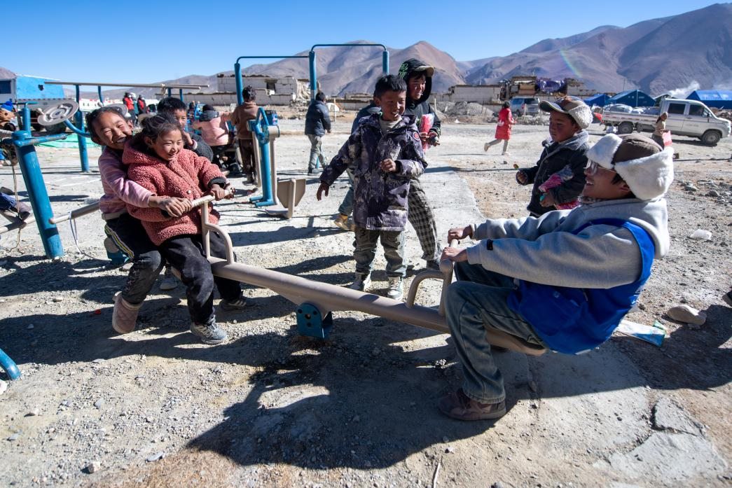 1月11日，在定日縣措果鄉(xiāng)塘仁村安置點(diǎn)，西藏星光社會(huì)工作服務(wù)中心志愿者和孩子們一起玩耍，進(jìn)行災(zāi)后心理疏導(dǎo)。人民網(wǎng)記者 翁奇羽攝
