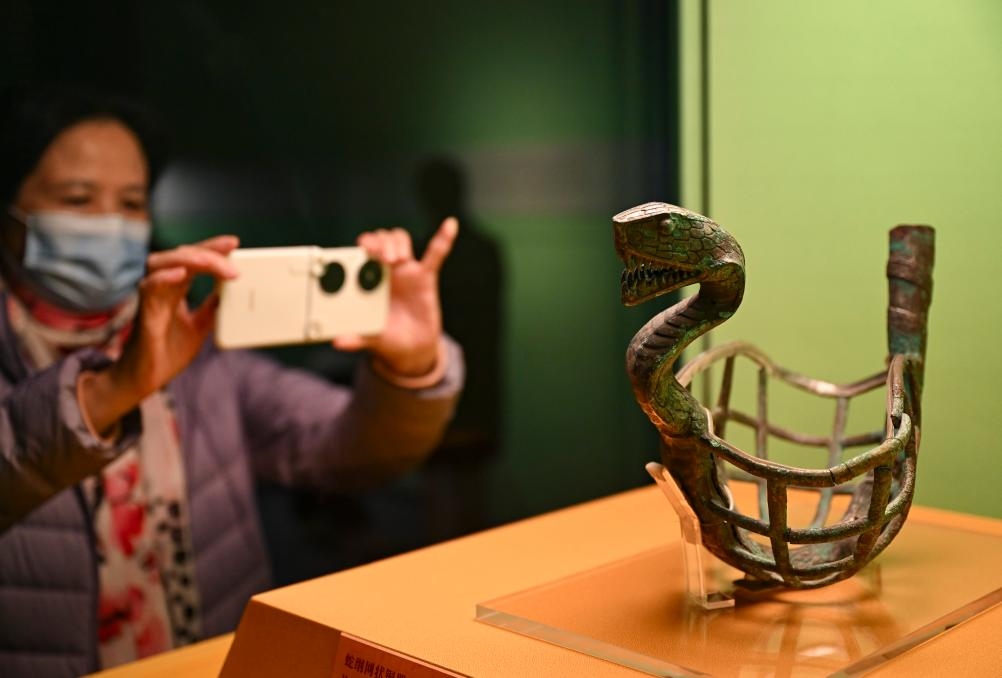 1月14日，觀眾在上海博物館蛇年迎春展拍攝展品蛇綱網(wǎng)狀銅器。新華社發(fā)（陳浩明攝）