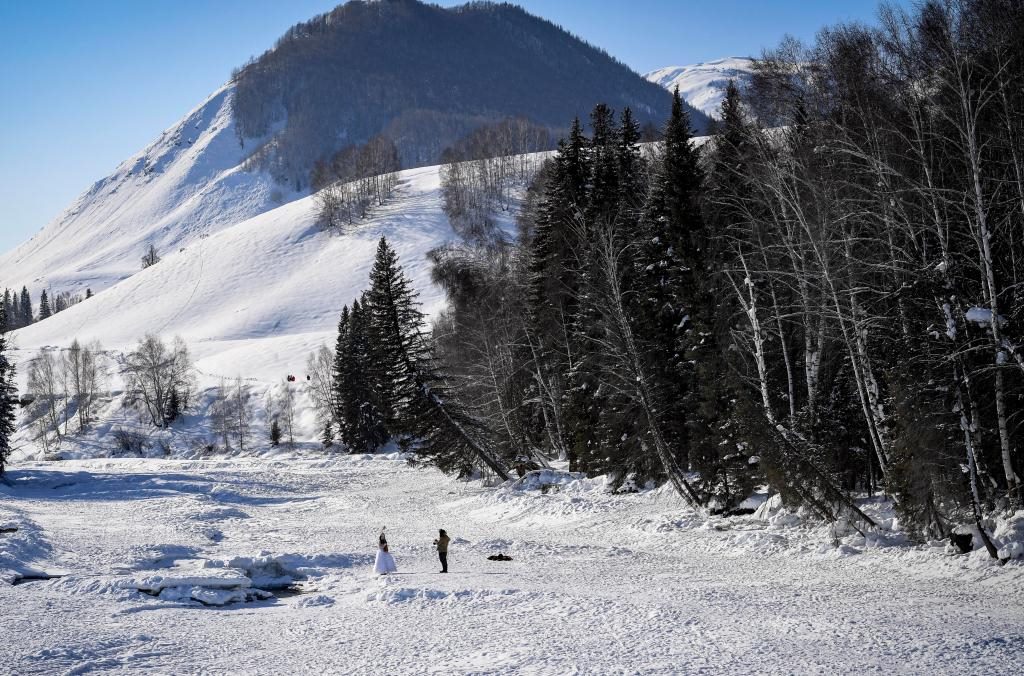 2024年2月5日，兩名游客在新疆阿勒泰地區(qū)布爾津縣禾木村拍照。新華社記者 馬鍇 攝