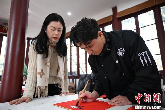 1月20日，外籍留學(xué)生在西泠印社社員李硯指導(dǎo)下寫福。當日，來自巴西、馬來西亞、加納、哈薩克斯坦的外籍留學(xué)生在浙江杭州西泠印社體驗福貼、春聯(lián)和篆刻，感受古老的中國傳統(tǒng)文化。中新社記者 王剛 攝