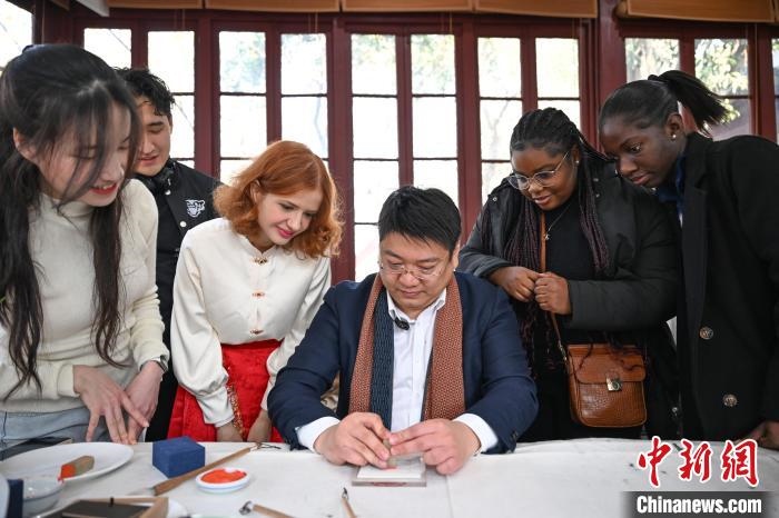 1月20日，篆刻家王臻向外籍留學(xué)生展示篆刻印章。當日，來自巴西、馬來西亞、加納、哈薩克斯坦的外籍留學(xué)生在浙江杭州西泠印社體驗福貼、春聯(lián)和篆刻，感受古老的中國傳統(tǒng)文化。中新社記者 王剛 攝
