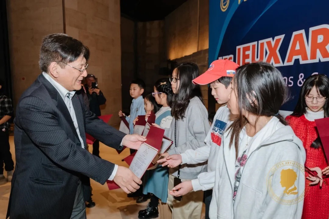 圖2：亞丁為獲獎兒童頒發(fā)證書。法中交流促進(jìn)會供圖