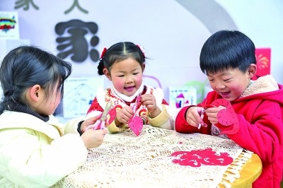 圖為孩子們在老師指導(dǎo)下制作蛇年主題剪紙。 新華社記者 徐昱攝