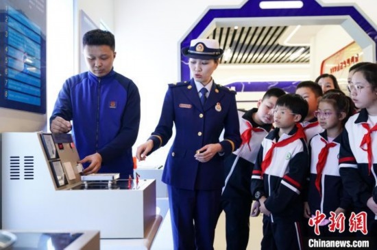 圖為學(xué)生們參觀道里區(qū)消防救援大隊(duì)消防科普體驗(yàn)館內(nèi)電器火災(zāi)演示實(shí)驗(yàn)臺(tái)。中新社記者 趙宇航 攝