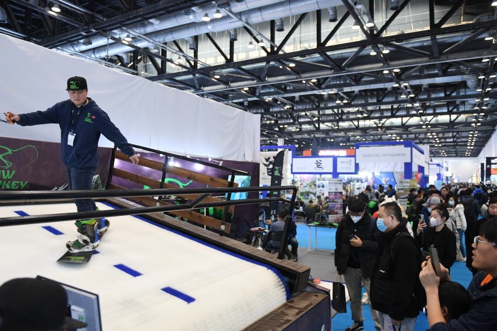 2023年2月11日，參觀者在展會上了解一款模擬滑雪設(shè)備。當(dāng)日，2023亞洲運動用品與時尚展在國家會議中心拉開帷幕。新華社記者 張晨霖 攝