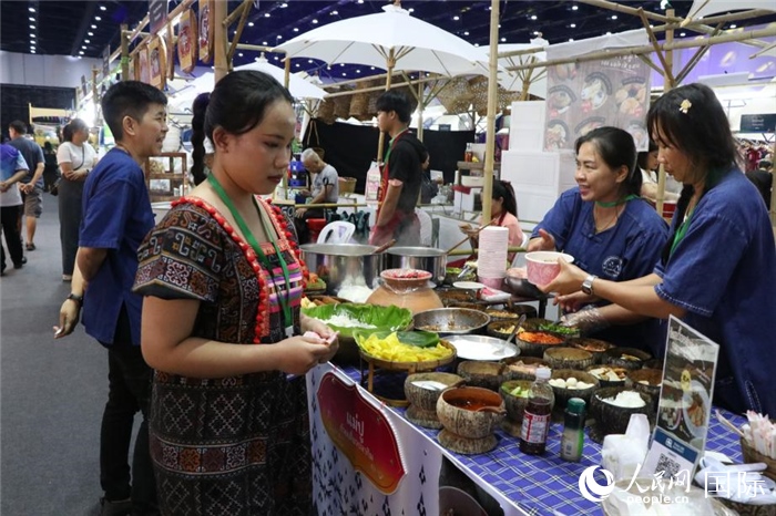 游客在攤位前購(gòu)買(mǎi)特色美食。朱瀟逸攝
