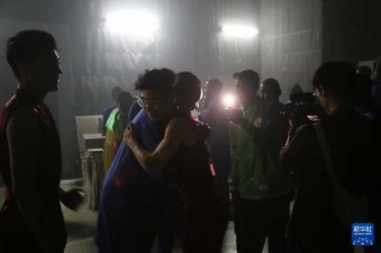 4月10日，在塞內(nèi)加爾首都達喀爾的國家大劇院，中央音樂學院進擊打擊樂團成員與塞內(nèi)加爾杜杜·恩迪亞耶·羅斯打擊樂團成員在演出后臺擁抱。新華社記者 司源 攝