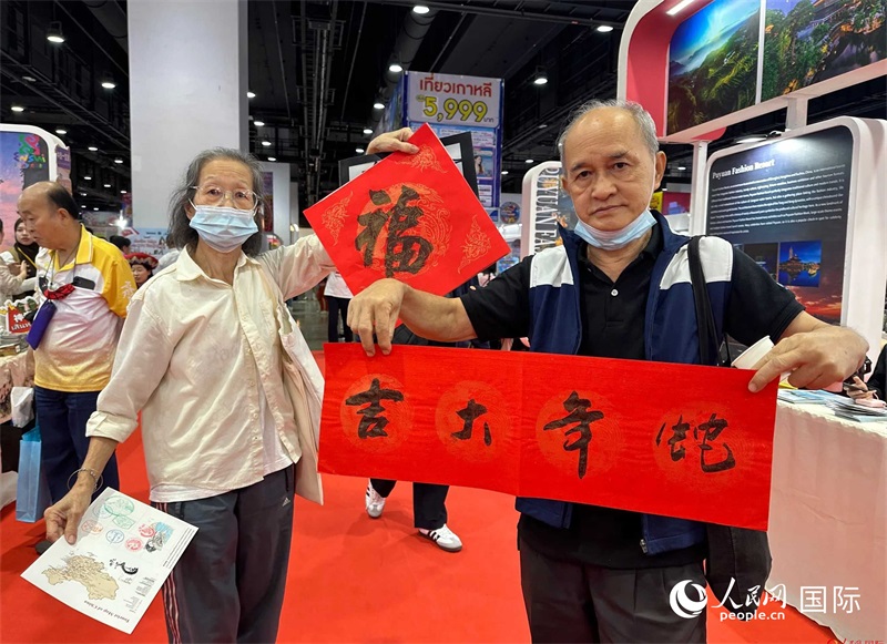 2025蛇年春節(jié)，泰國市民展示他們領(lǐng)到的華人手寫春聯(lián)。人民網(wǎng)記者 簡承淵攝