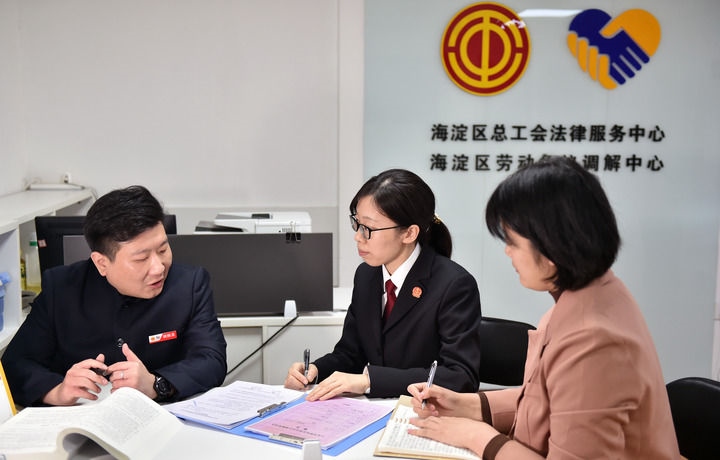 2025年3月6日，在北京市海淀區(qū)總工會勞動爭議調(diào)解中心，海淀區(qū)人民法院法官王琰（中）與該中心工作人員就糾紛化解情況進行溝通。新華社記者 趙婷婷 攝
