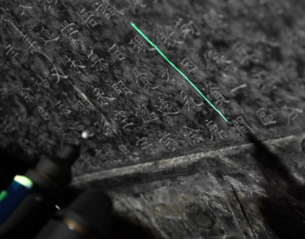 2025年4月9日，龍門石窟研究院工作人員在古陽(yáng)洞使用關(guān)節(jié)臂掃描儀對(duì)《龍門二十品》之一進(jìn)行數(shù)字化掃描。新華社記者 李嘉南 攝