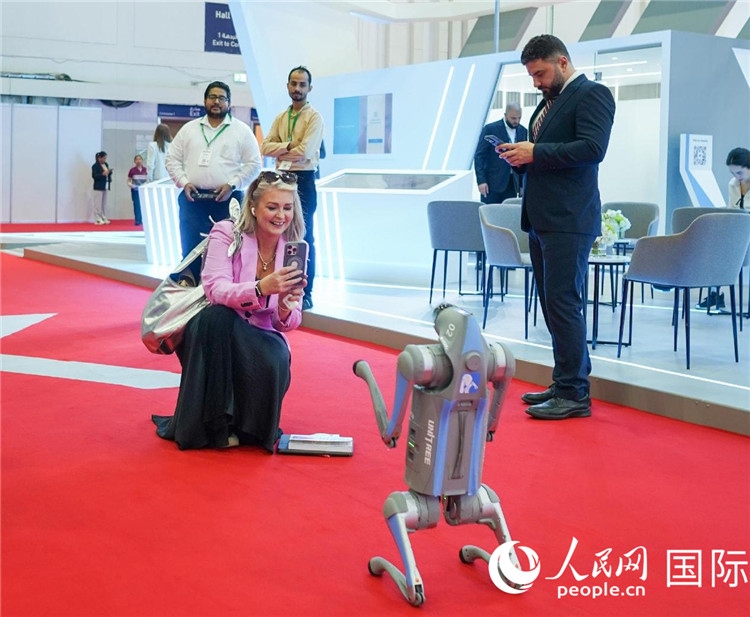 與會(huì)嘉賓被中企機(jī)器人吸引。人民網(wǎng) 塔里克·易卜拉欣攝