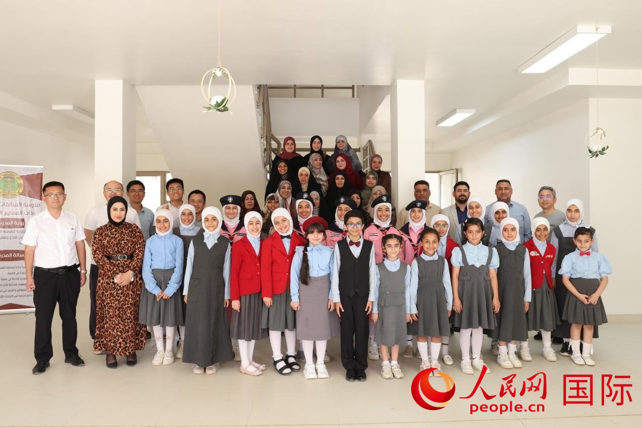 中國(guó)電建員工與阿爾穆塔?阿里卡特國(guó)際學(xué)校的師生及政府官員等合影。人民網(wǎng)記者 薛丹攝