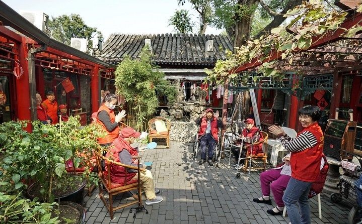 2024年10月12日，鐘樓灣胡同的老年人在社區(qū)內(nèi)的四合院養(yǎng)老驛站休閑。2017年起，北京市先后開(kāi)展了兩輪背街小巷環(huán)境整治提升行動(dòng)，完整保留了中軸線生活建筑群的歷史信息，并根據(jù)居民的生活和居住方式進(jìn)行適配化的更新和改造，極大地改善了生活環(huán)境。2023年鐘樓灣胡同被評(píng)為“北京最美街巷”。