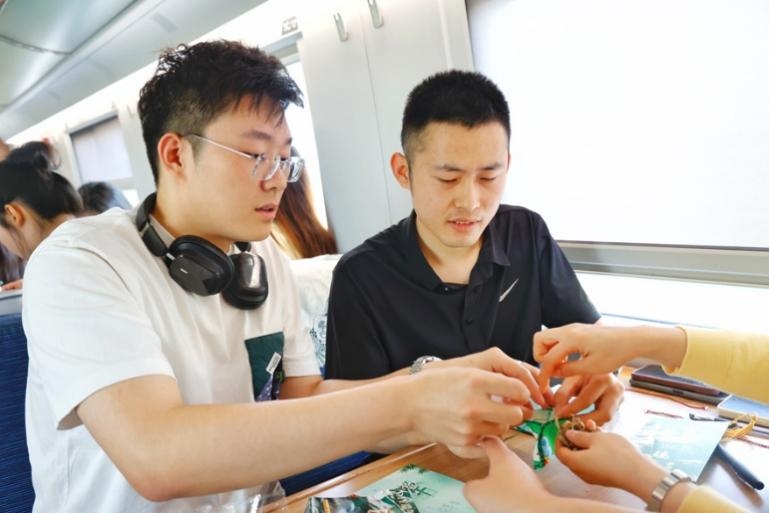G232次旅客親手制作端午荷包和五彩繩。王磊攝