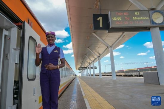 5月31日，在蒙內(nèi)鐵路內(nèi)羅畢站，一名乘務(wù)員在即將開往蒙巴薩的E2次列車旁等候乘客。新華社記者 楊光 攝