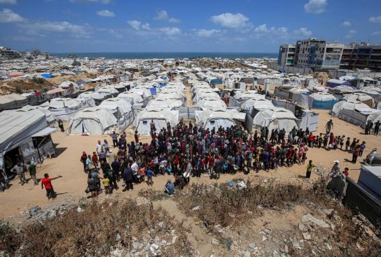 5月28日，人們在加沙城西部的沙提難民營等待領(lǐng)取救助食物。新華社發(fā)（里澤克·阿卜杜勒賈瓦德攝）