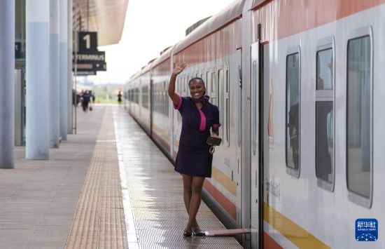 5月31日，在蒙內(nèi)鐵路內(nèi)羅畢站，一名乘務(wù)員在即將開往蒙巴薩的E2次列車旁等候乘客。新華社記者 李亞輝 攝