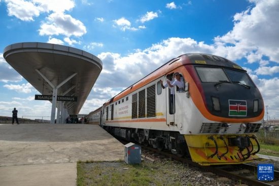 5月31日，在蒙內(nèi)鐵路內(nèi)羅畢站，機(jī)車駕駛員蔣立平（右）和博爾在即將開往蒙巴薩的E2次列車上揮手致意。新華社記者 楊光 攝