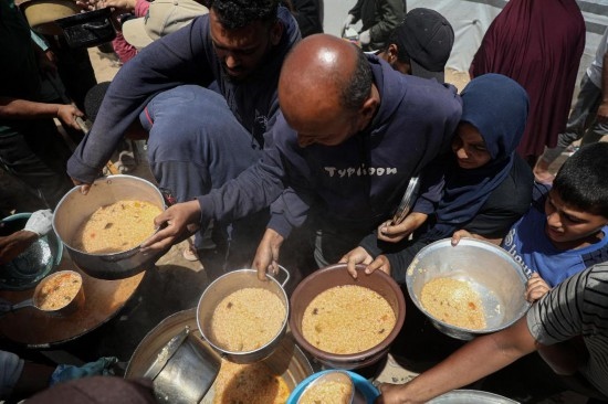 5月28日，人們在加沙城西部的沙提難民營領(lǐng)取救助食物。新華社發(fā)（里澤克·阿卜杜勒賈瓦德攝）