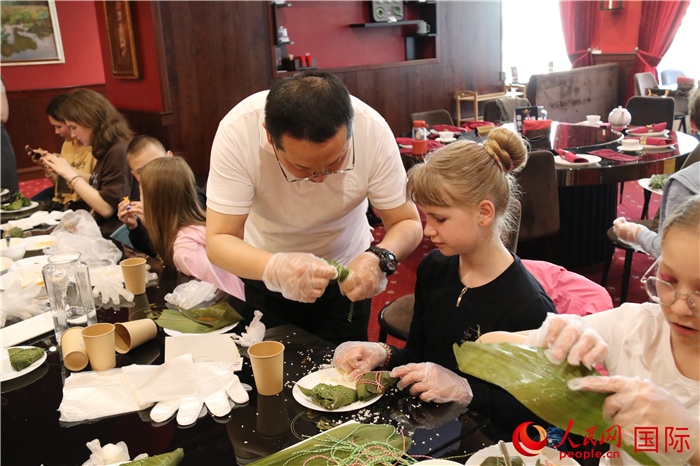 烏克蘭兒童學習體驗包粽子。人民網(wǎng)記者蔡子暢攝