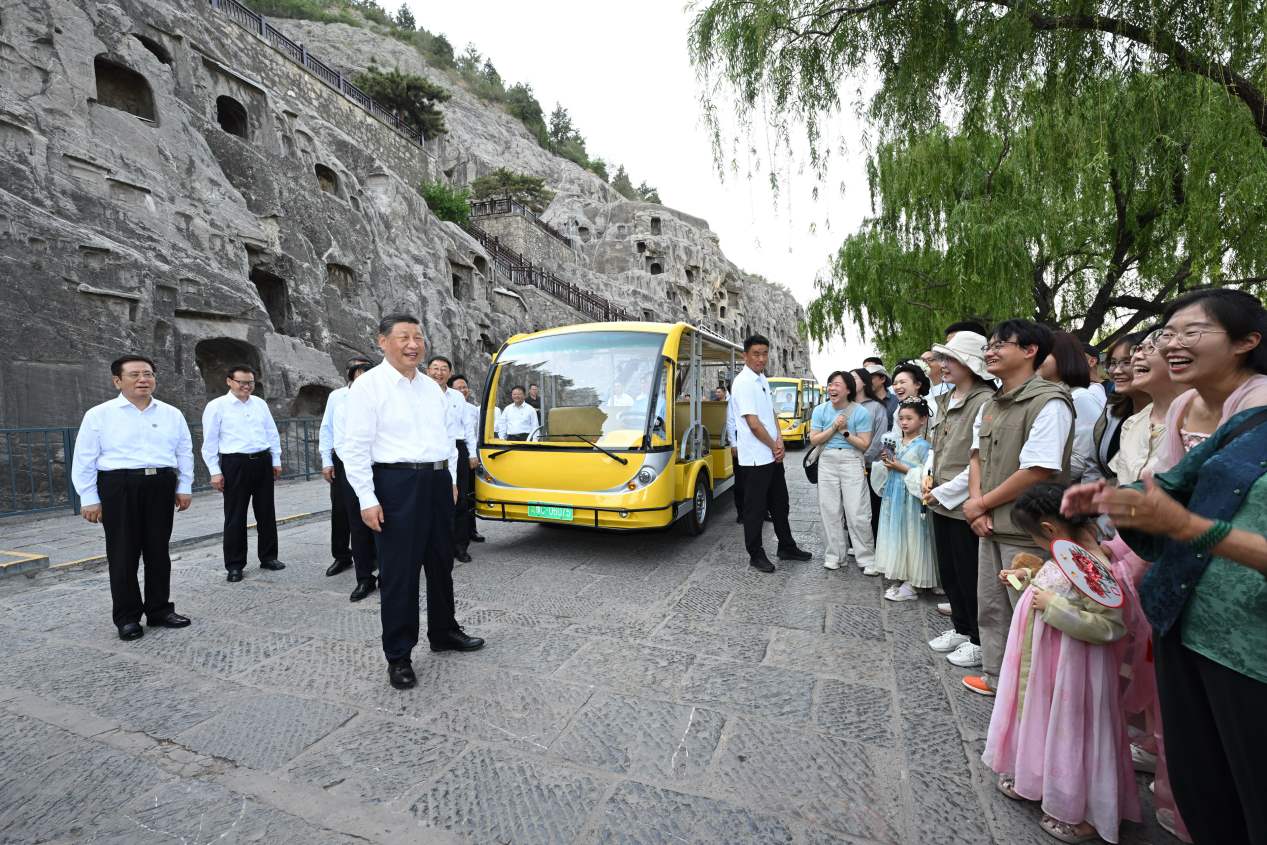 5月19日，習近平在洛陽龍門石窟考察時，同游客親切交流。